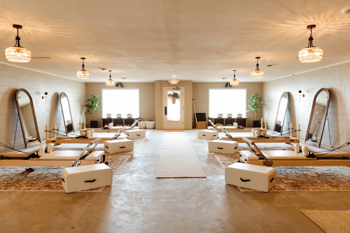 Bright reformer studio with arched mirrors and warm pendant lights