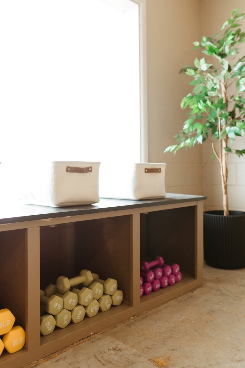 Hand weights neatly stacked in wooden studio cubbies